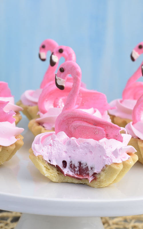 cut raspberry meringue tarts with chocolate flamingo decoration