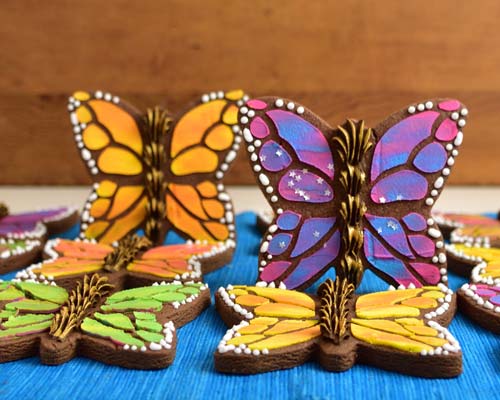 Butterfly cookies decorated with orange, yellow, pink and purple royal icing.