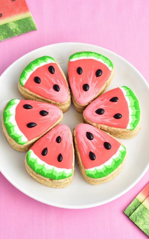 Watermelon pinata cookie arranged in a circle on a plate.
