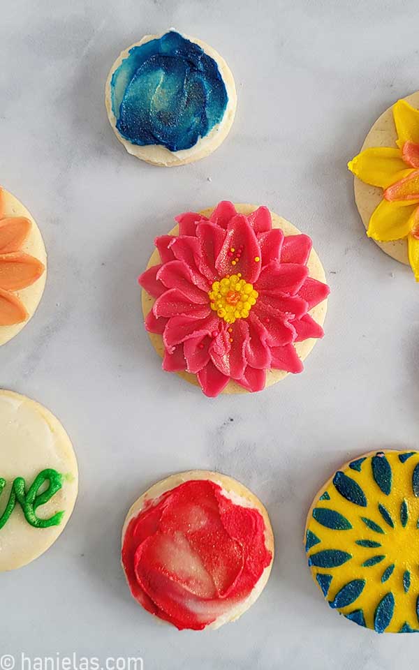 Round cookies decorated with buttercream frosting using a palette knife.