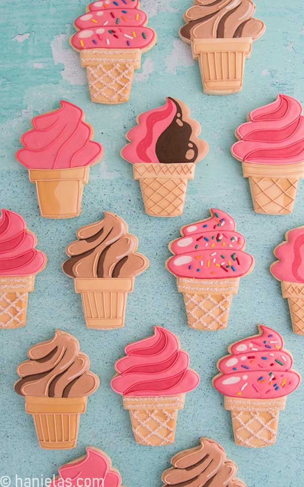Decorated ice cream cone cookie on teal background.