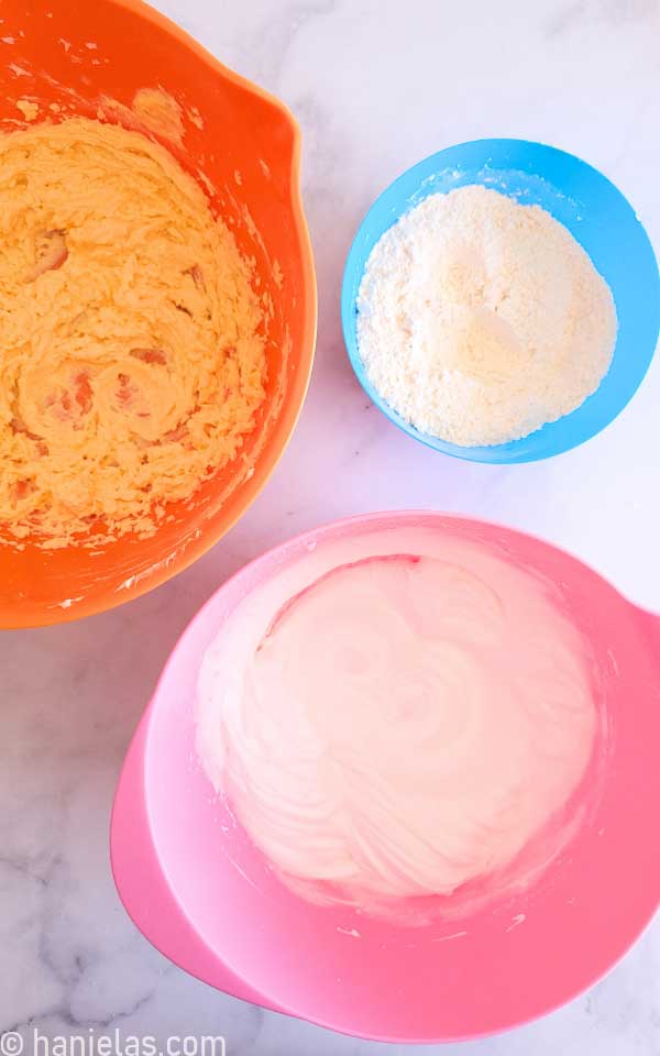 Three mixing bowl with flour, meringue and butter.