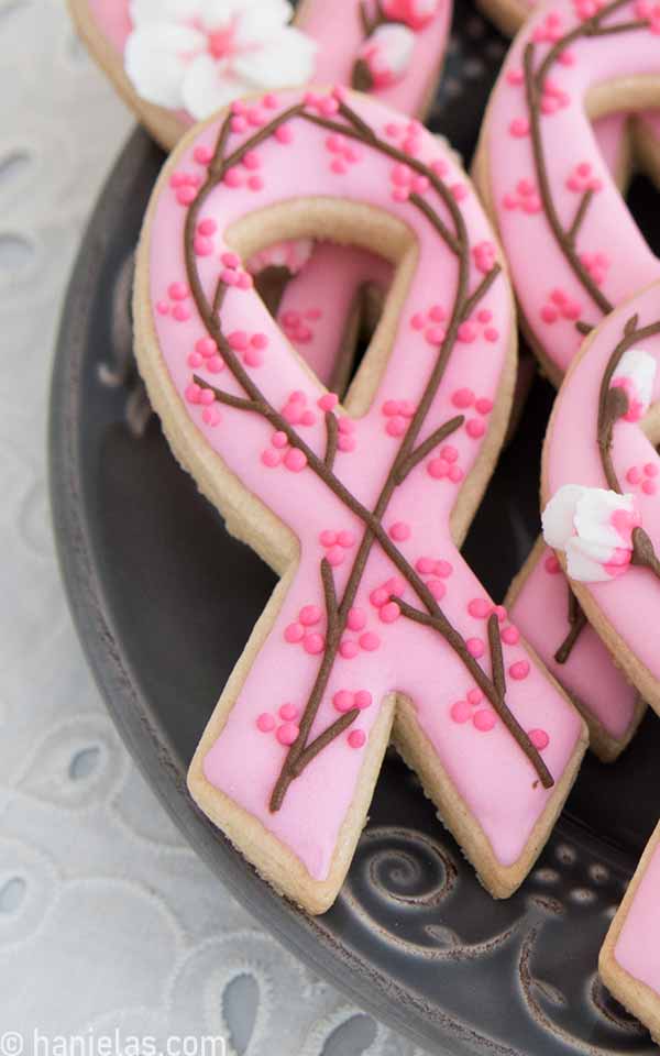 Close up of pink ribbon cookie decorated with royal icing.