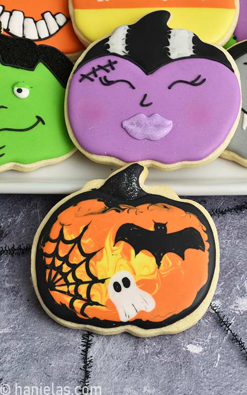 Pumpkin cookie decorated with wet on wet Halloween design.