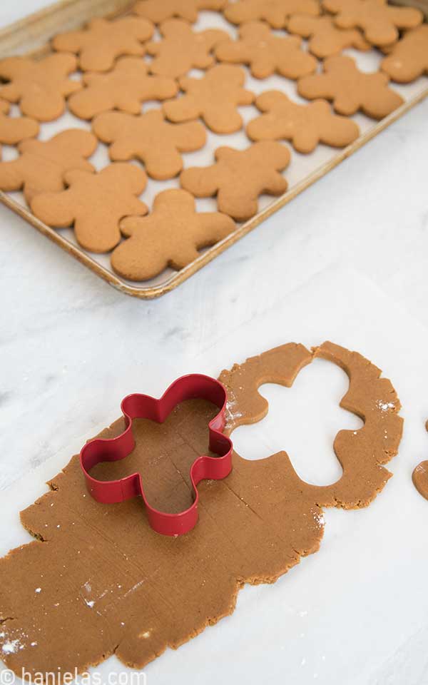 Rolled out cookie dough with a gingerbread men cookie cutter on the top.