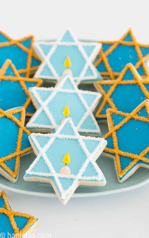 Six point star cookies decorated with blue icing.