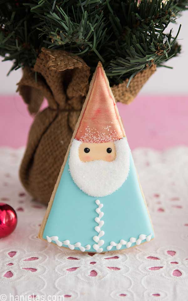 Decorated sugar cookies leaning onto a small decorative tree.