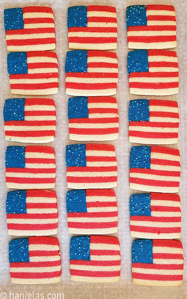 Baked square cookies on a baking sheet lined with parchment.