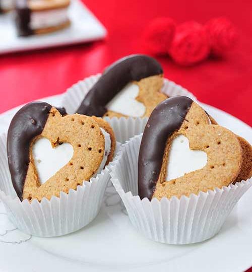 Heart s'mores sandwiches nested in paper liners.