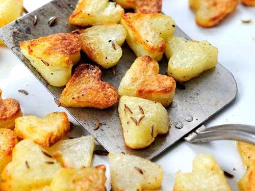 Roasted potatoes on a metal spatula.