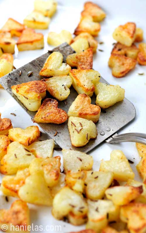Roasted potatoes on a metal spatula.