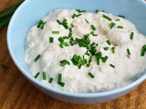 Tartar sauce in a bowl garnished with chopped chives.