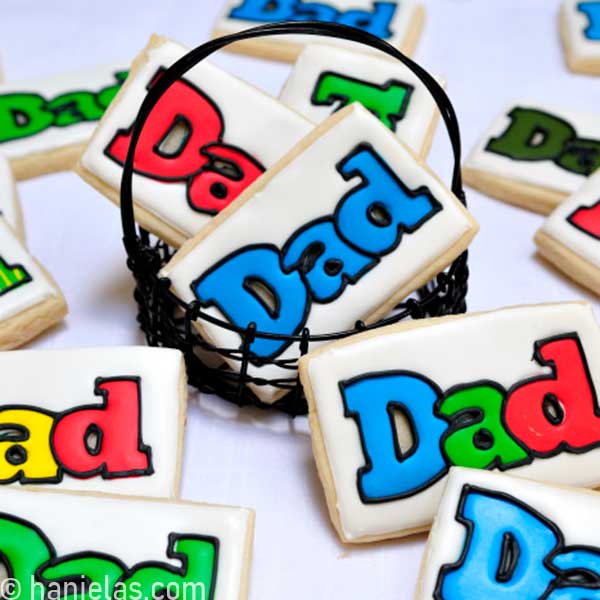 Decorated cookies in a black wire basket.