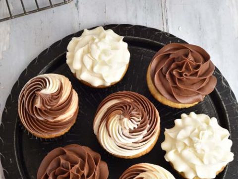 Cupcakes frosted with chocolate and vanilla frosting on a plate.