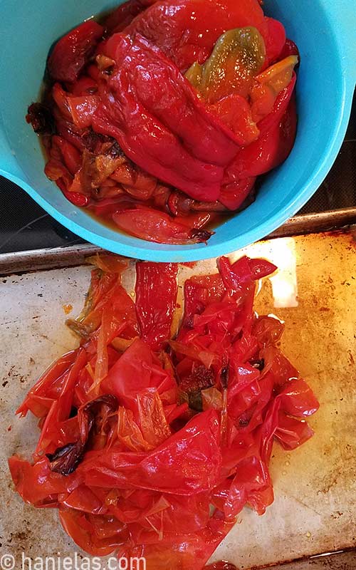 Skinned peppers in a bowl. And skins on a baking sheet.