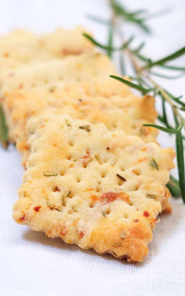 Detail of baked crackers, showing rosemary and prosciutto.