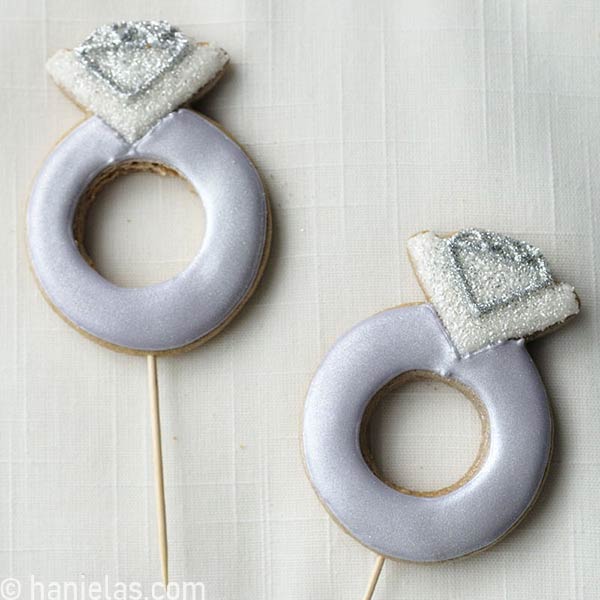 Decorated cookies with a toothpick inserted in them.