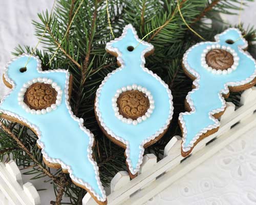 Christmas ornament cookies displayed on a green pine branch.