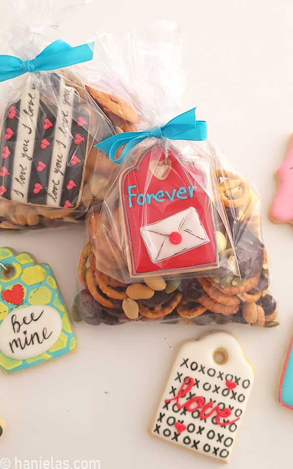 Snack mix in a bag with a red cookie attached.