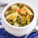 Green bean vegetable soup in white bowl.