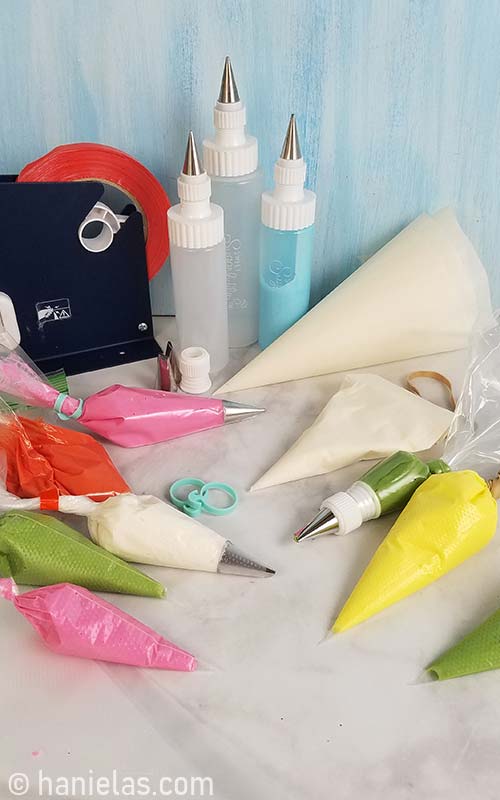 Piping bags and icing bottles filled with royal icing.