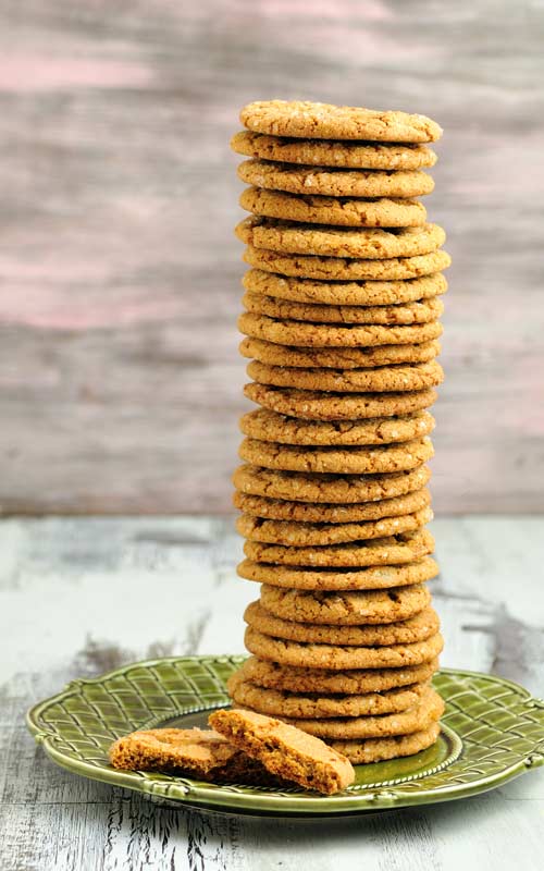 Cookies stacked into a tall tower on a green plate.