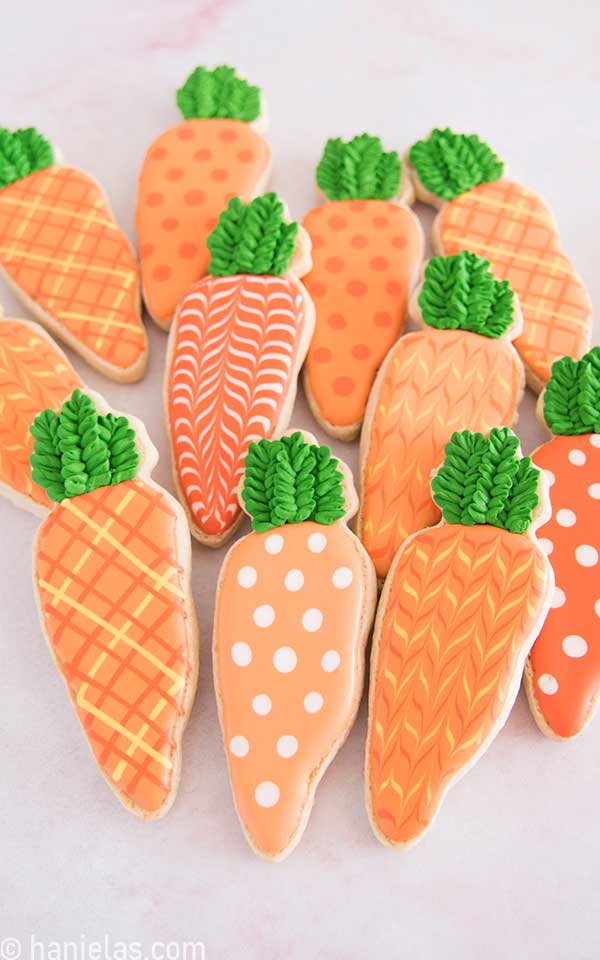 Carrot cookies decorated with orange royal icing.