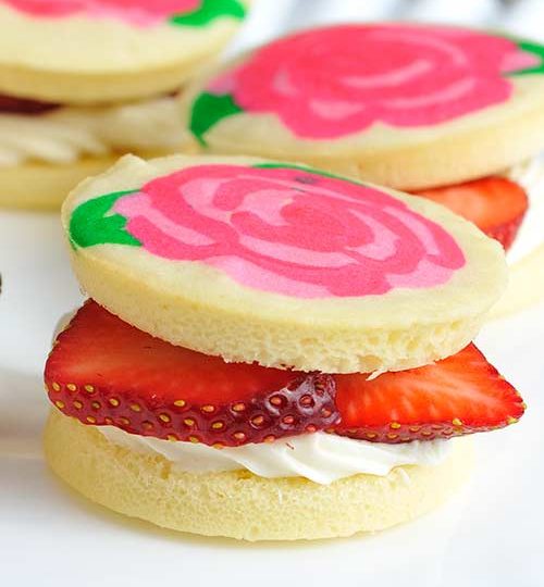 Small sponge cake filled with cream cheese frosting and sliced strawberries.