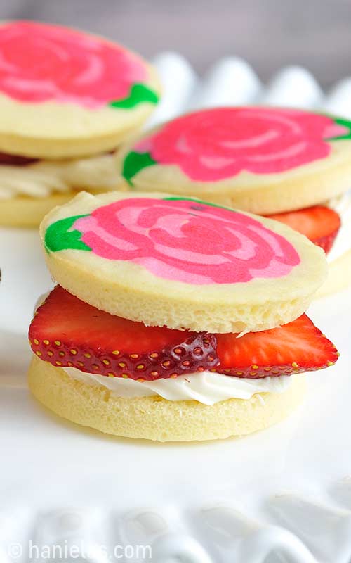 Small sponge cake filled with cream cheese frosting and sliced strawberries.