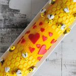 Cake roll decorated with fondant bees and heart.