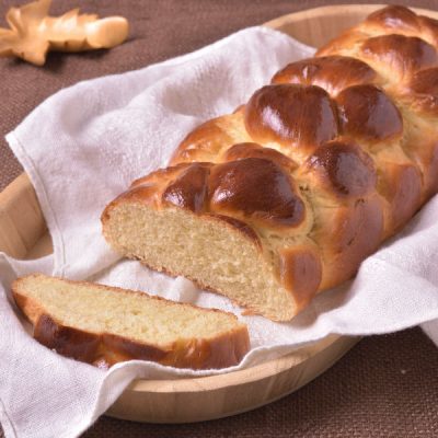 Challah bread loaf on a kitchen towel.