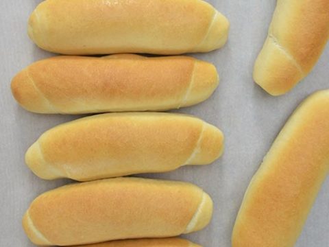 Baked bread rolls on a cutting board.