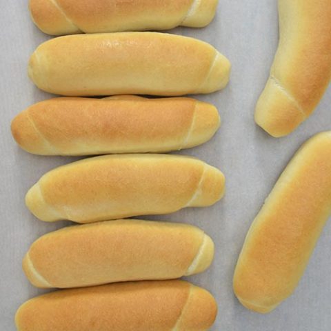 Baked bread rolls on a cutting board.