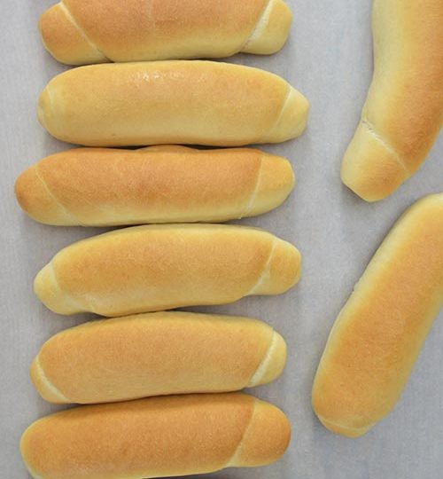 Baked bread rolls on a cutting board.