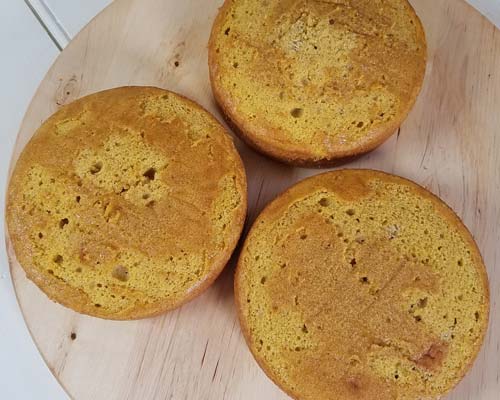 3 baked cakes on a wooden board.