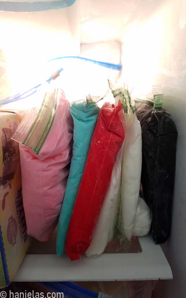 Sandwich bags standing upright in a freezer.