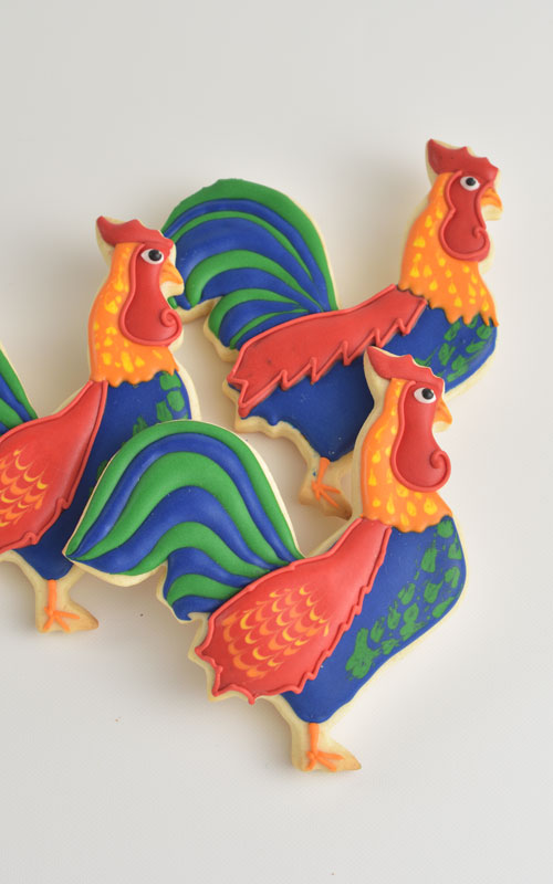 Colorful rooster cookies decorated with royal icing