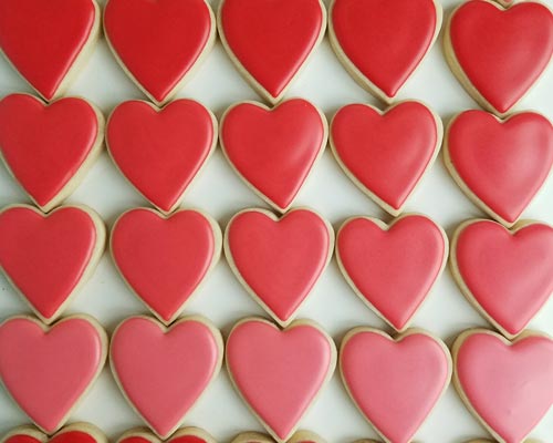 Red heart cookies iced with red 15 second royal icing consistency.