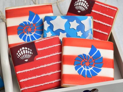 Seashell patriotic sugar cookies stenciled with royal icing.