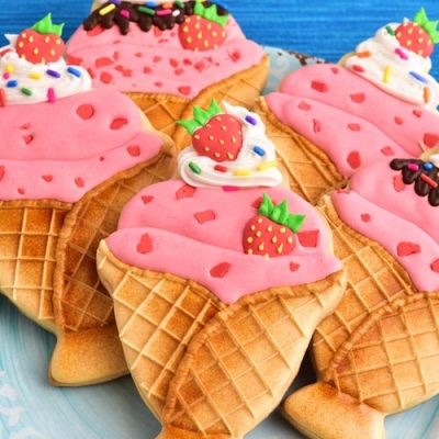 Decorated strawberry ice cream sundae cookies on a plate.