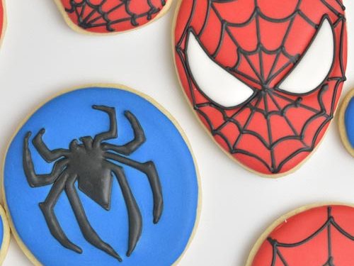 Cookie iced with red icing and decorated with black spiderweb design.