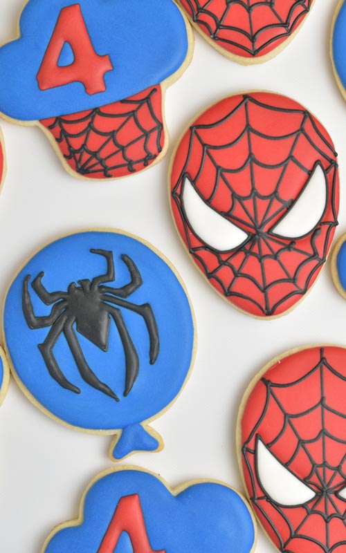 Cookie iced with red icing and decorated with black spiderweb design.