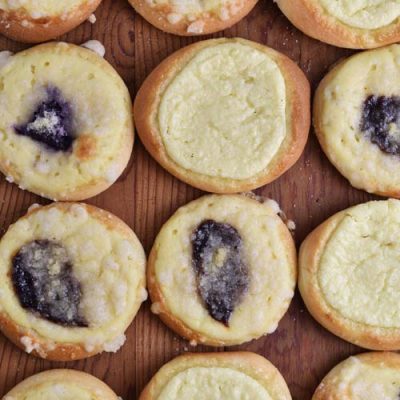 Baked filled yeast buns on a wooden cutting board.