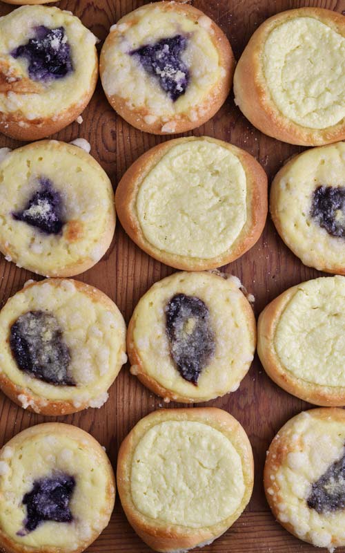 Baked filled yeast buns on a wooden cutting board.