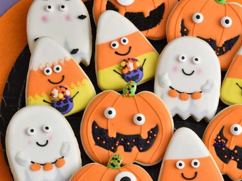 Royal icing decorated cookies on a black plate.