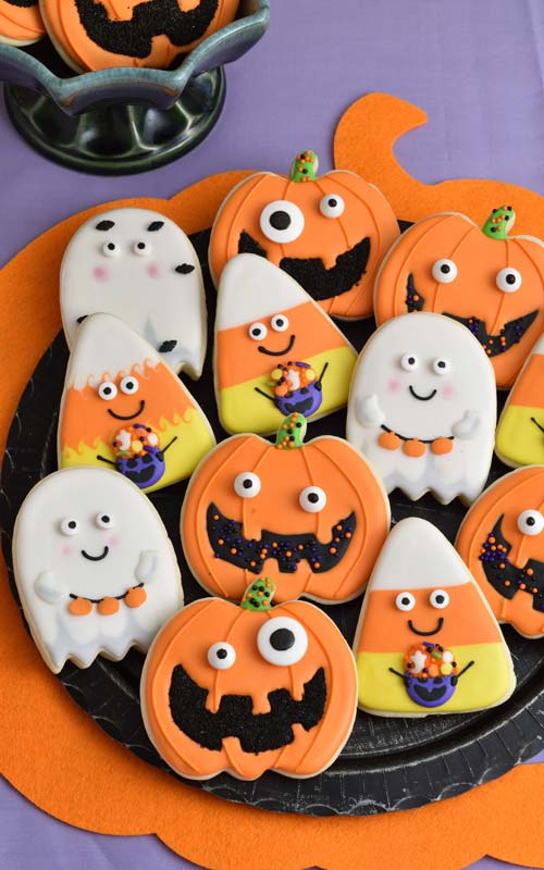 Royal icing decorated cookies on a black plate.