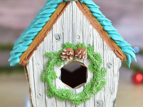 Gingerbread birdhouse displayed on a table.