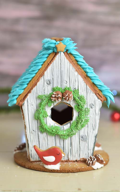 Gingerbread birdhouse displayed on a table.