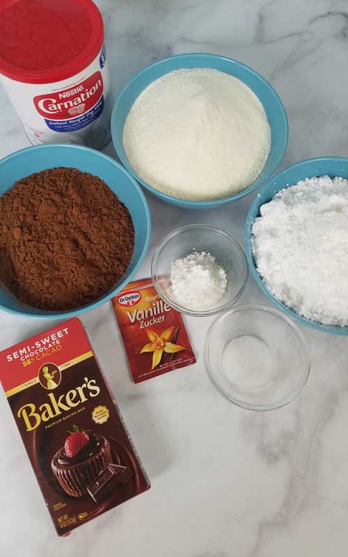 Bowls with dry ingredients to make hot chocolate mix.