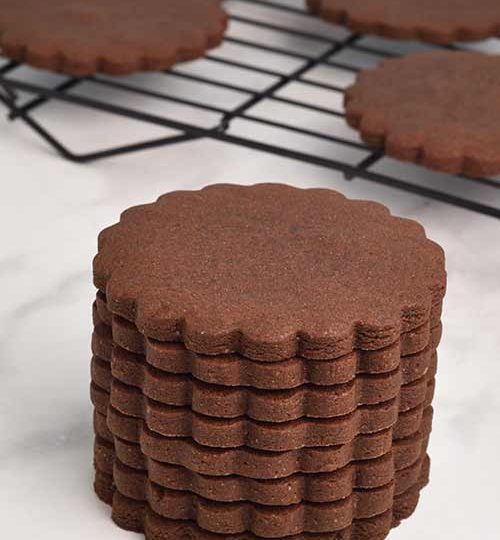 Baked scalloped edge cookies stacked on top of each other.